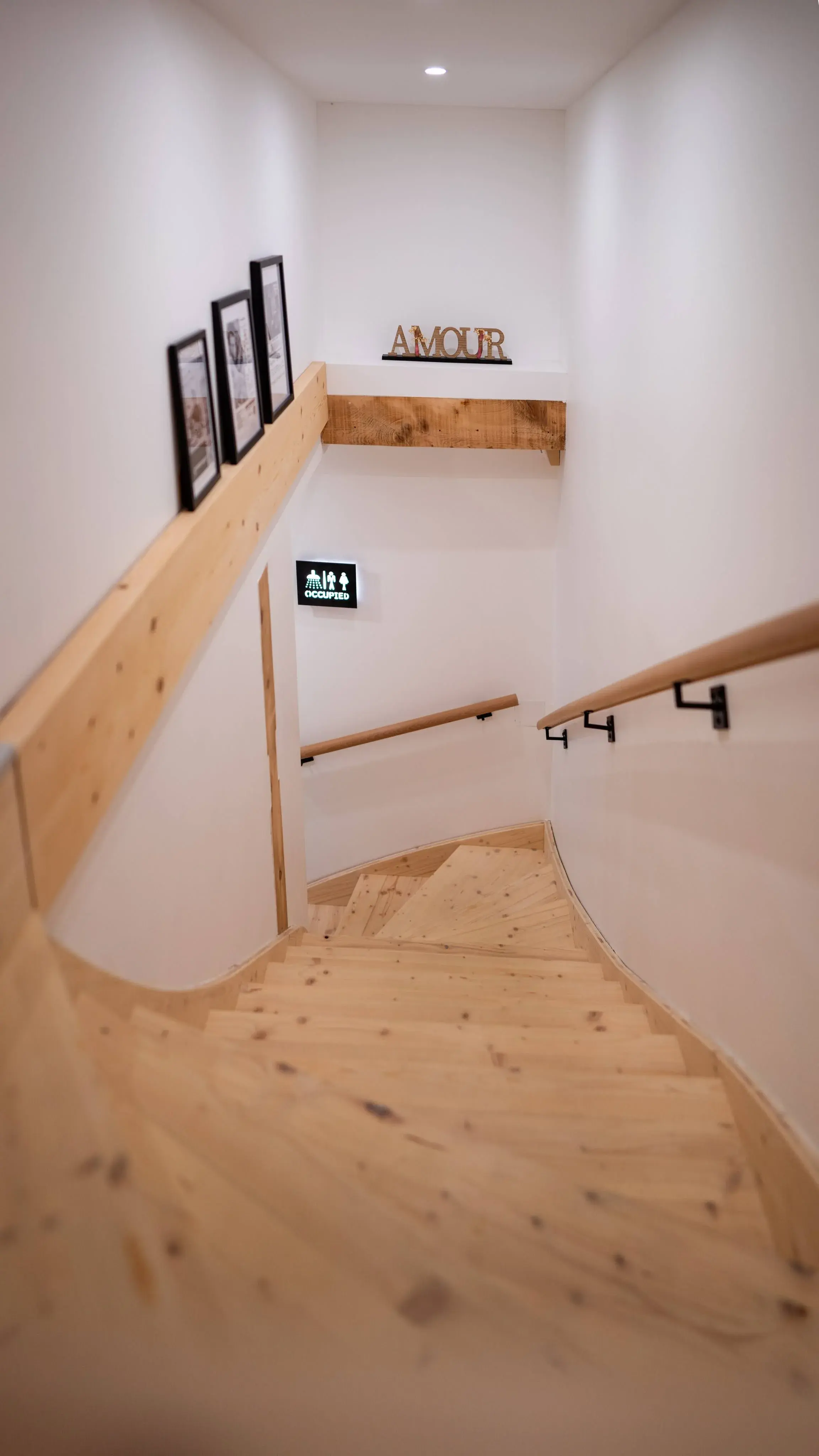 Escalier en bois clair menant à l'étage du gîte