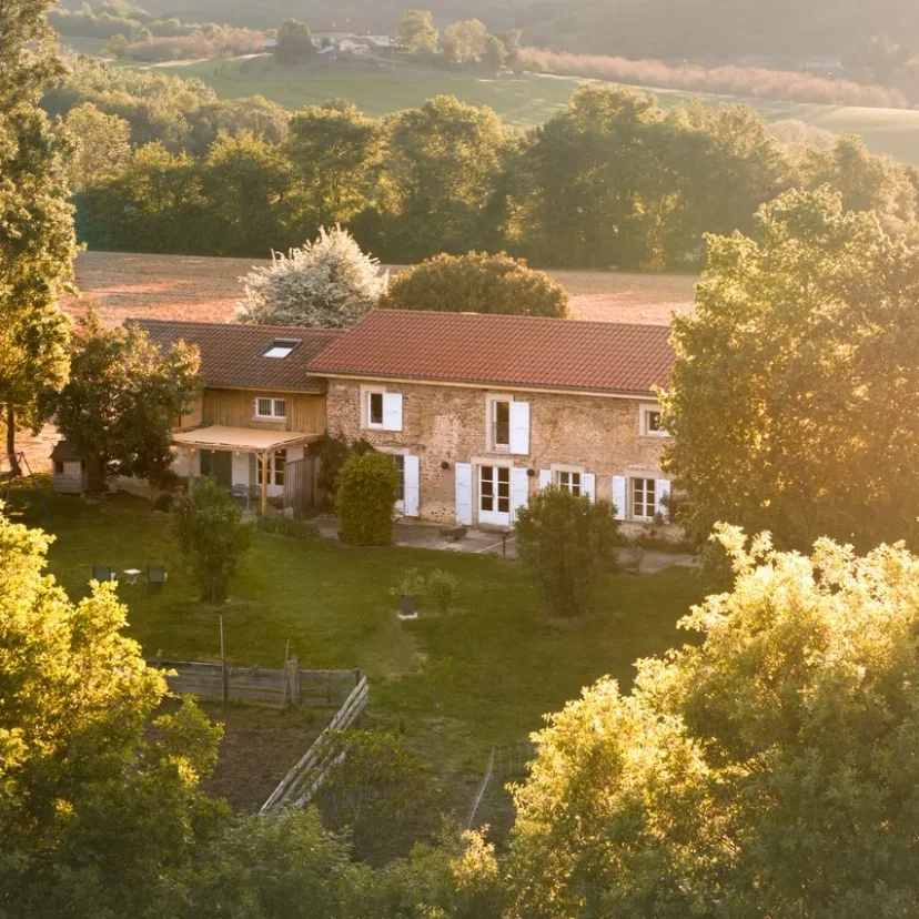 Vue aerienne du domaine L'Hospitalier dans son ecrin de verdure, lumiere doree de fin de journee