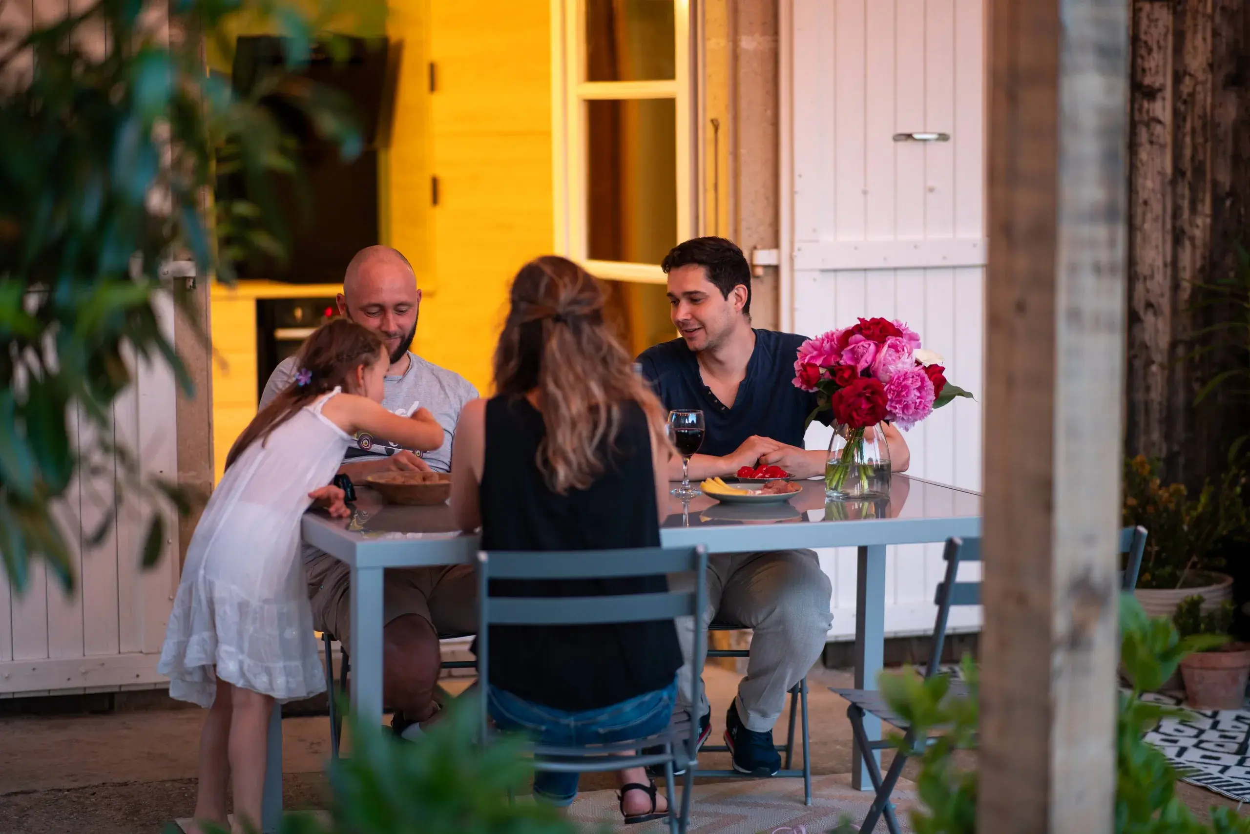 Repas en famille sur la terrasse du gîte L'Hospitalier, lumière de fin de journée