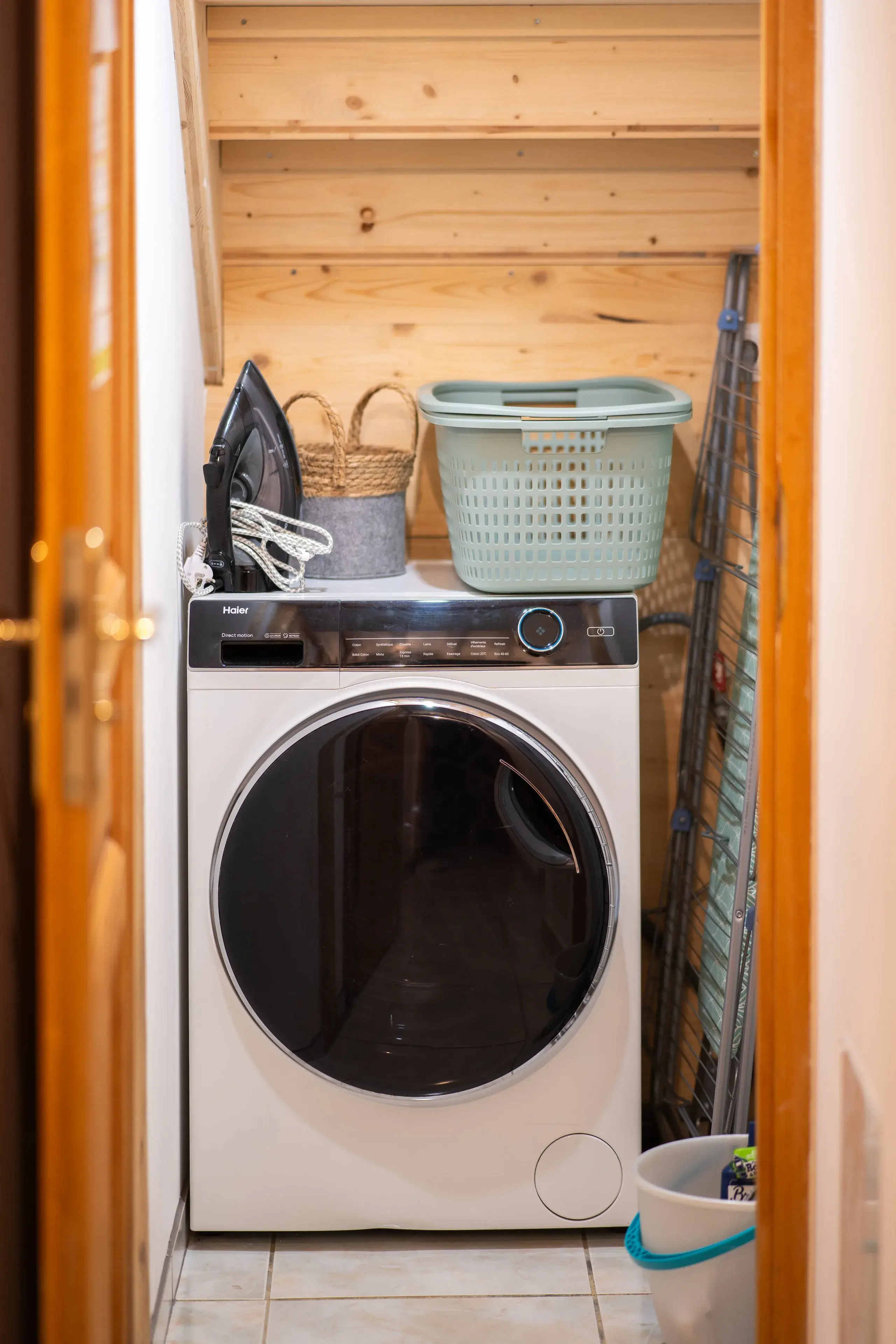 Coin buanderie du gite avec lave-linge et rangements